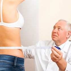 Doctor measuring the waist of a model