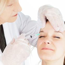 Female doctor injecting a model above her right eye