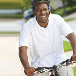 Smiling man with bike helmet riding a bike